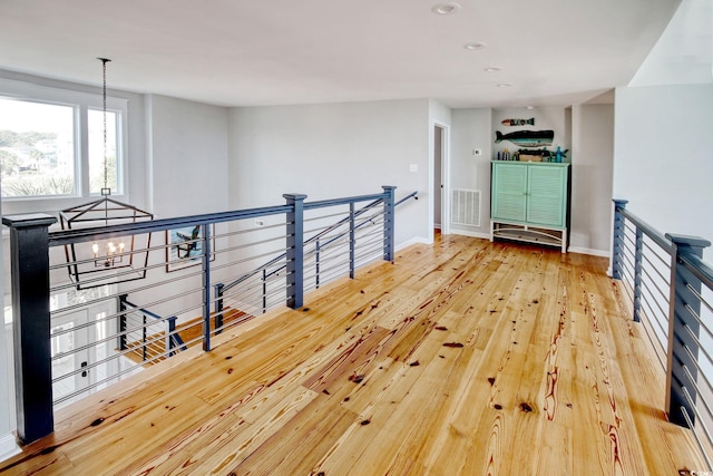 hallway featuring a notable chandelier and wood-type flooring