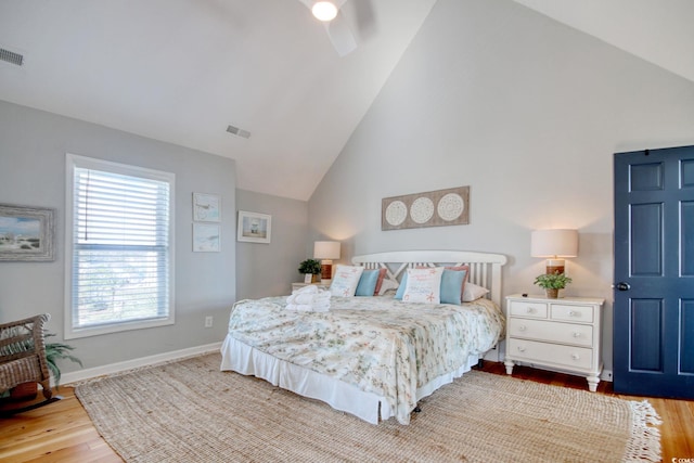 bedroom with light hardwood / wood-style flooring and high vaulted ceiling