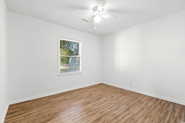 spare room featuring ceiling fan, a textured ceiling, and light wood-type flooring