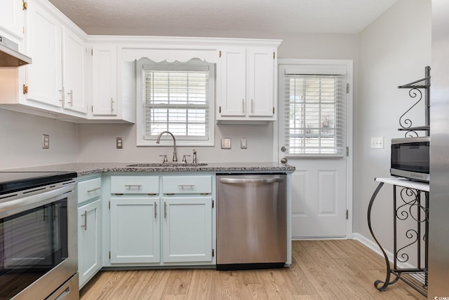 kitchen featuring white cabinetry, appliances with stainless steel finishes, sink, and light wood-type flooring