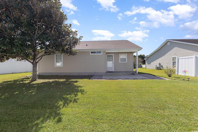 back of house with a patio and a lawn