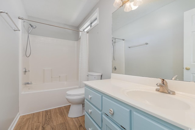 full bathroom with hardwood / wood-style flooring, vanity, shower / tub combo with curtain, and toilet