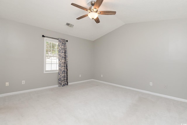 carpeted empty room featuring ceiling fan, vaulted ceiling, and a textured ceiling