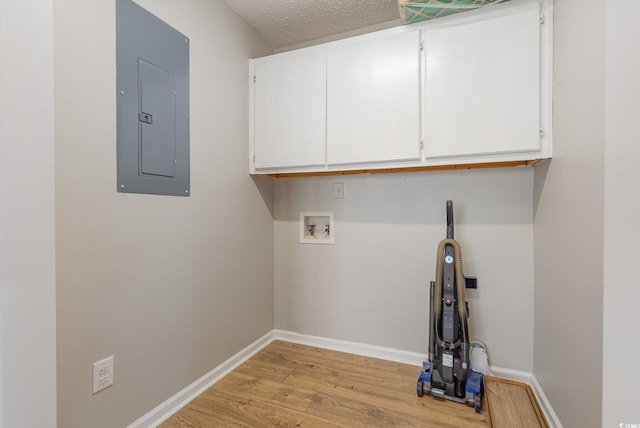 laundry area with cabinets, a textured ceiling, light wood-type flooring, electric panel, and washer hookup