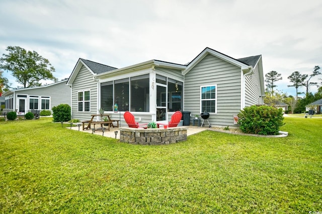 back of house featuring a sunroom, a yard, and a patio area