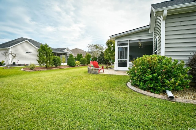 view of yard with an outdoor fire pit and a sunroom