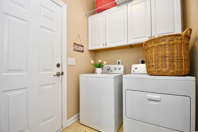 clothes washing area featuring washing machine and clothes dryer and cabinets