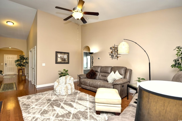 living room with ceiling fan, dark hardwood / wood-style floors, and high vaulted ceiling