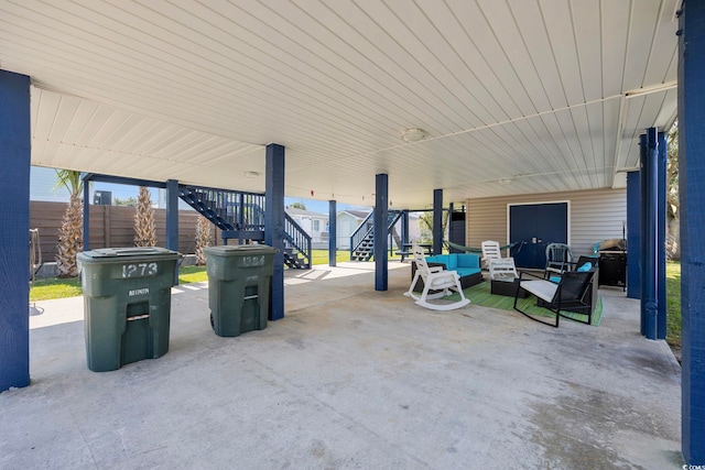 view of patio with outdoor lounge area, fence, and stairway