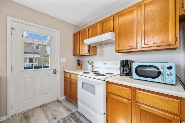 kitchen featuring light countertops, light wood finished floors, white electric range, and under cabinet range hood