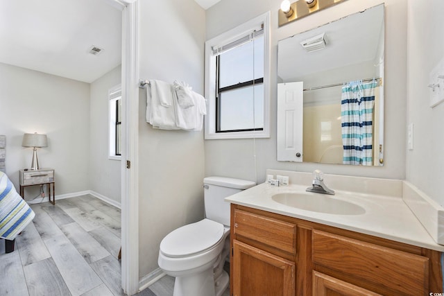 bathroom with vanity, visible vents, toilet, curtained shower, and wood finished floors