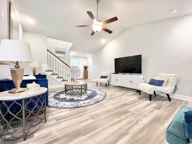 living room with light hardwood / wood-style flooring, lofted ceiling, and ceiling fan