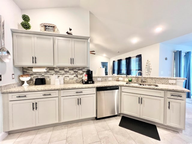 kitchen featuring lofted ceiling, stainless steel dishwasher, sink, and kitchen peninsula