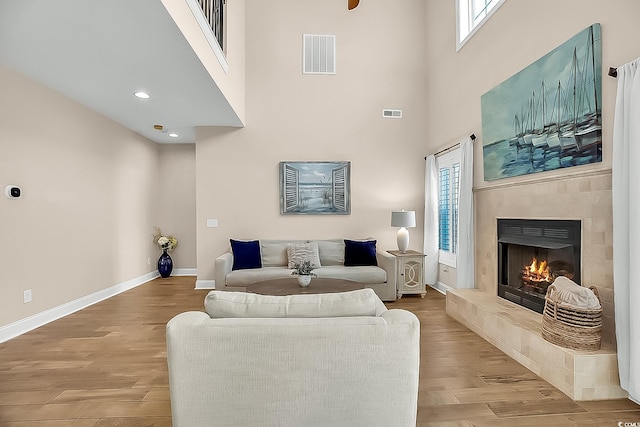 1002 Summers Pl, North Myrtle Beach, SC 29582 - living area featuring a high ceiling, visible vents, baseboards, a fireplace, and light wood-style flooring