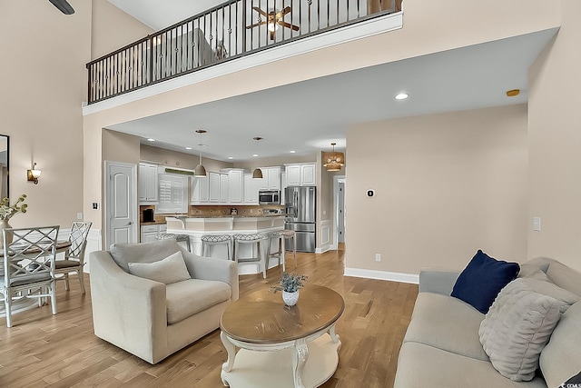 1002 Summers Pl, North Myrtle Beach, SC 29582 - living area featuring light wood finished floors, a high ceiling, and recessed lighting
