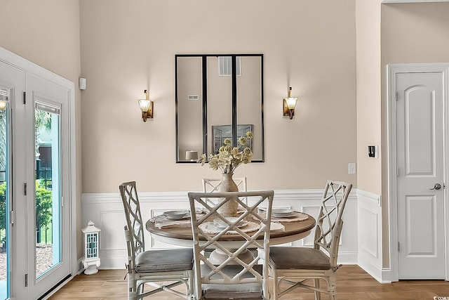 1002 Summers Pl, North Myrtle Beach, SC 29582 - dining room with wood finished floors, a decorative wall, and wainscoting