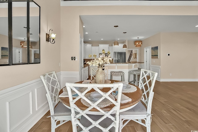 1002 Summers Pl, North Myrtle Beach, SC 29582 - dining room with wainscoting, a decorative wall, wood finished floors, and recessed lighting