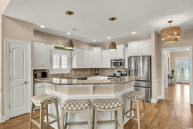 1002 Summers Pl, North Myrtle Beach, SC 29582 - kitchen with stainless steel appliances, a sink, tasteful backsplash, stone counters, and a breakfast bar