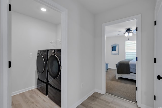 clothes washing area featuring ceiling fan, washing machine and dryer, and light wood-type flooring