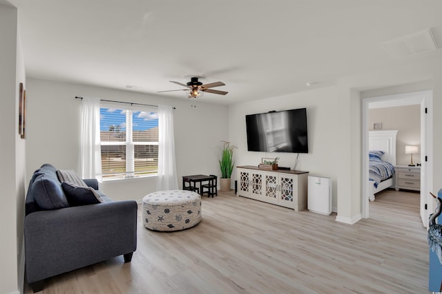 living room featuring light wood-type flooring and ceiling fan