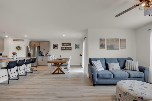 living room with ceiling fan and light hardwood / wood-style floors