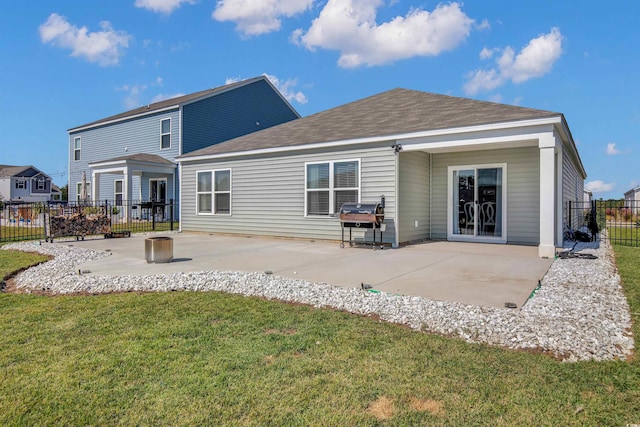 rear view of house with a lawn and a patio