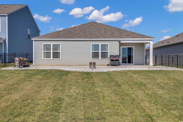 rear view of house featuring a lawn and a patio