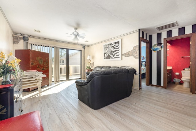 living room with ceiling fan, a textured ceiling, ornamental molding, and light hardwood / wood-style flooring