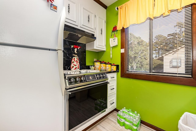 kitchen featuring light hardwood / wood-style flooring, white cabinets, white fridge, and stove