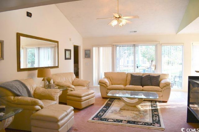 living room with a wealth of natural light, lofted ceiling, carpet flooring, and ceiling fan