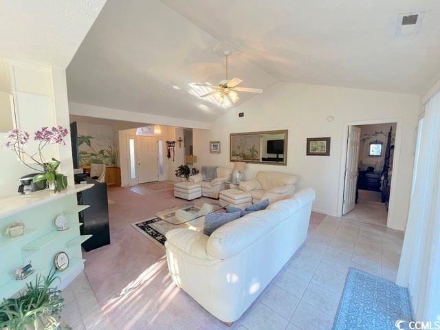 tiled living room with lofted ceiling and ceiling fan