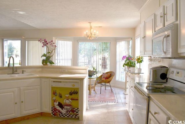 kitchen with white appliances, sink, a textured ceiling, white cabinetry, and a notable chandelier