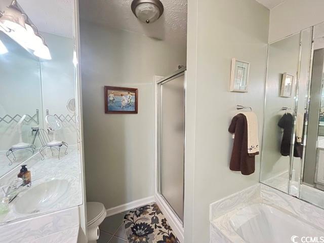 full bathroom with vanity, plus walk in shower, toilet, and tile patterned flooring