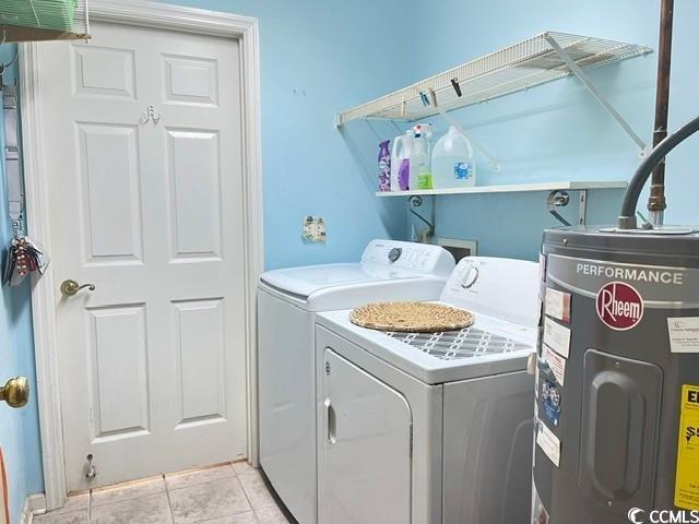 washroom featuring washer and dryer, light tile patterned floors, and water heater