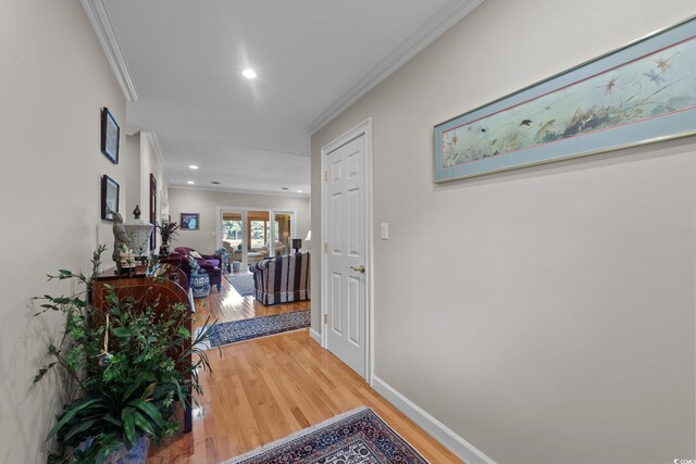 corridor with hardwood / wood-style floors and ornamental molding