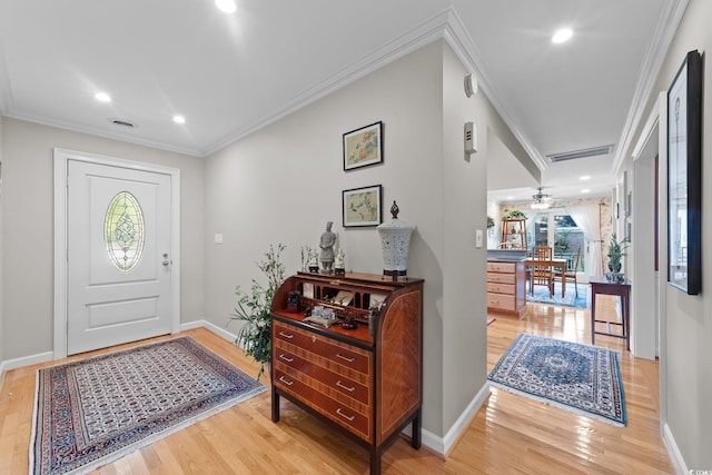 entryway featuring ornamental molding and light wood-type flooring