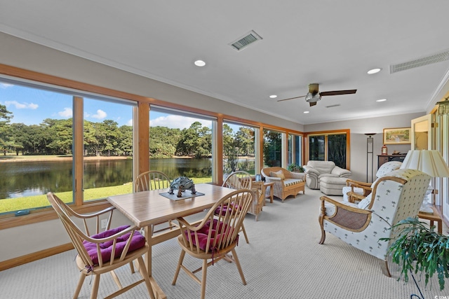 sunroom / solarium featuring a water view and ceiling fan