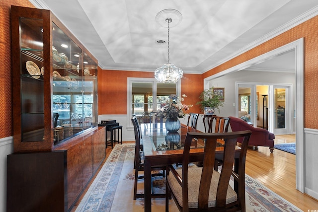 dining space with crown molding, hardwood / wood-style flooring, and a chandelier