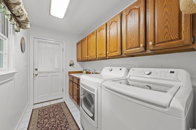 laundry area with light tile patterned flooring, cabinets, washer and clothes dryer, and sink