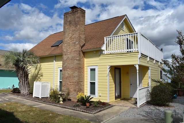 view of front of home featuring roof with shingles and a chimney