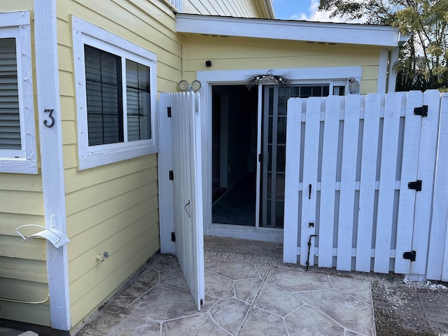 property entrance with a patio and fence