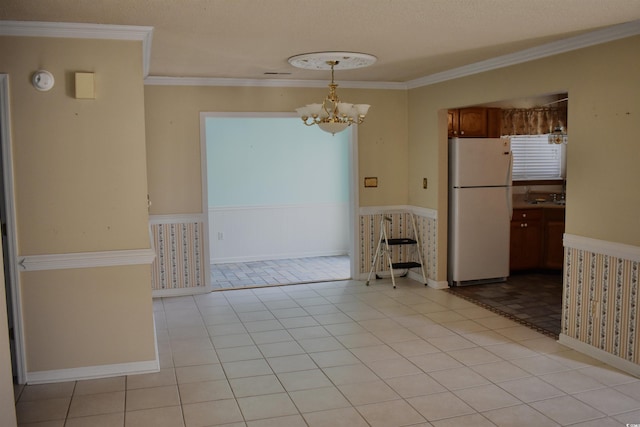 unfurnished dining area featuring crown molding, a textured ceiling, a chandelier, and light tile patterned flooring