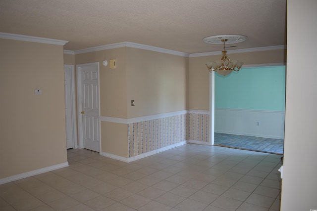 empty room featuring crown molding, a textured ceiling, light tile patterned flooring, and a chandelier