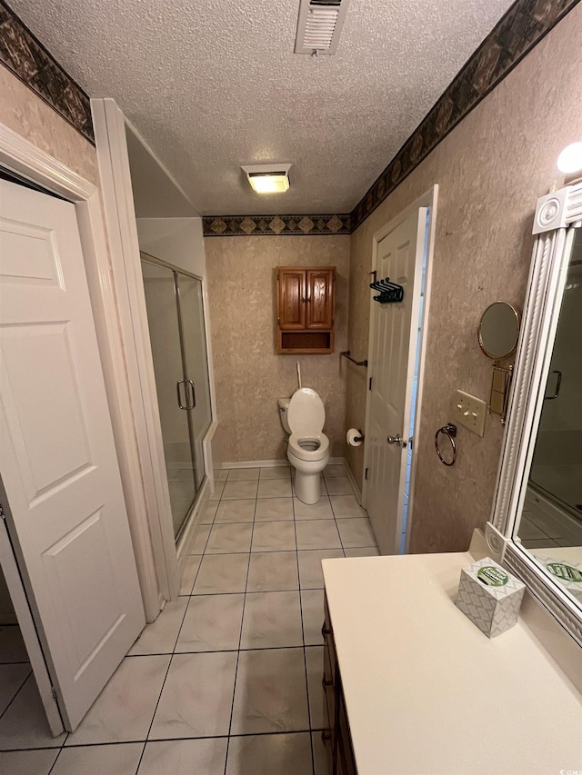 bathroom with a shower stall, a textured ceiling, vanity, tile patterned flooring, and visible vents
