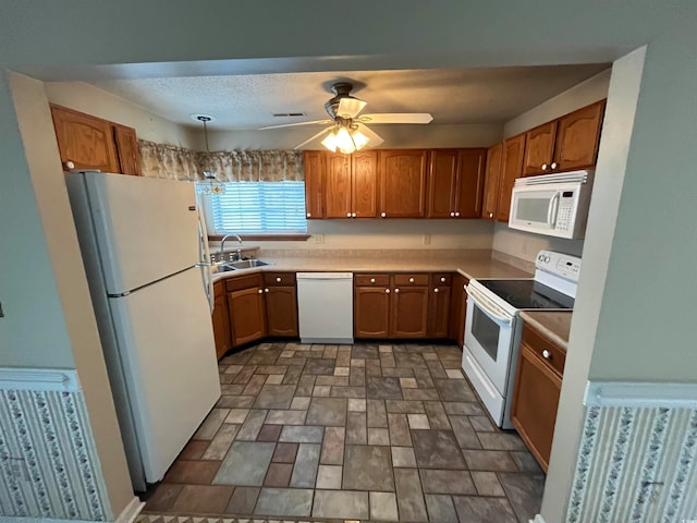 kitchen featuring decorative light fixtures, ceiling fan, sink, and white appliances