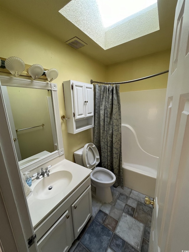 full bath with visible vents, shower / tub combo, toilet, vanity, and a skylight
