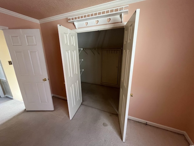 interior space with light carpet, baseboards, crown molding, and a textured ceiling