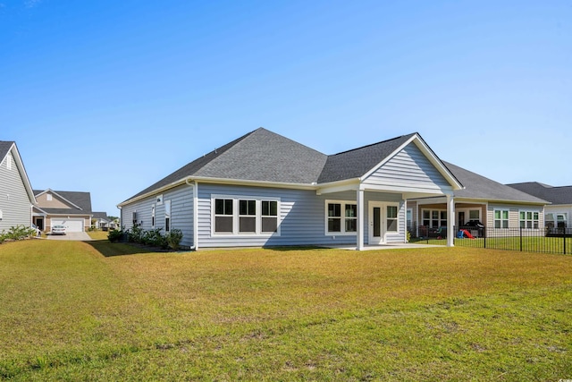 rear view of house featuring a porch and a yard