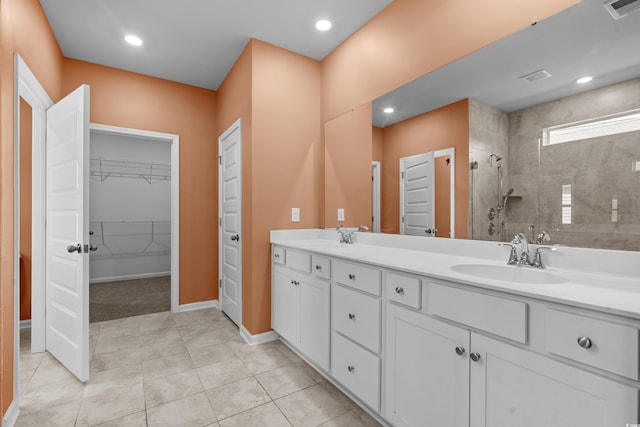 bathroom featuring tiled shower, vanity, and tile patterned floors