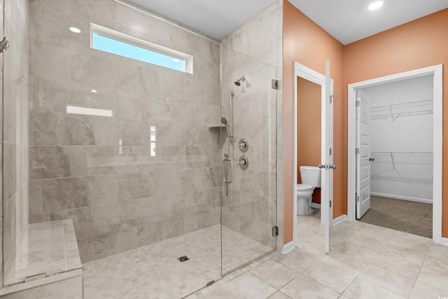 bathroom with toilet and a shower with shower door